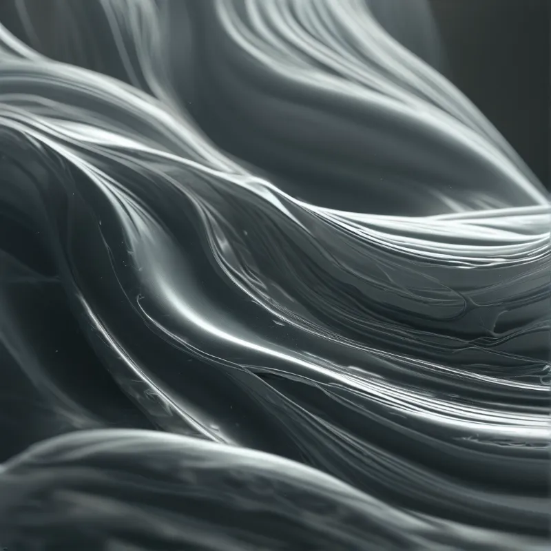 Shiny silver fluid moves in soft abstract waves across a dark background.