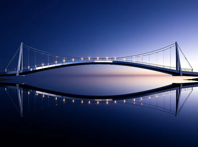 A white bridge spans calm water at dusk, with warm lights creating a symmetrical reflection in the dark blue surface.