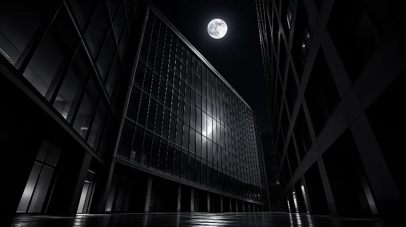 Monochrome night street between tall glass buildings, with a full moon above and wet ground reflecting the structures.