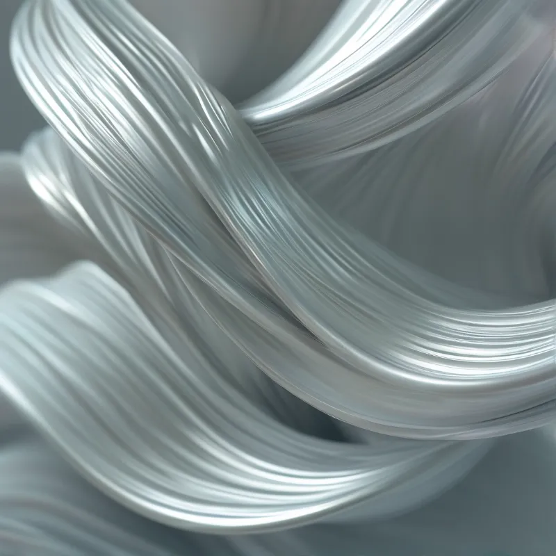 Silver fibrous strands overlap in curls, diffused light glistens along their long fine parallel ridges.