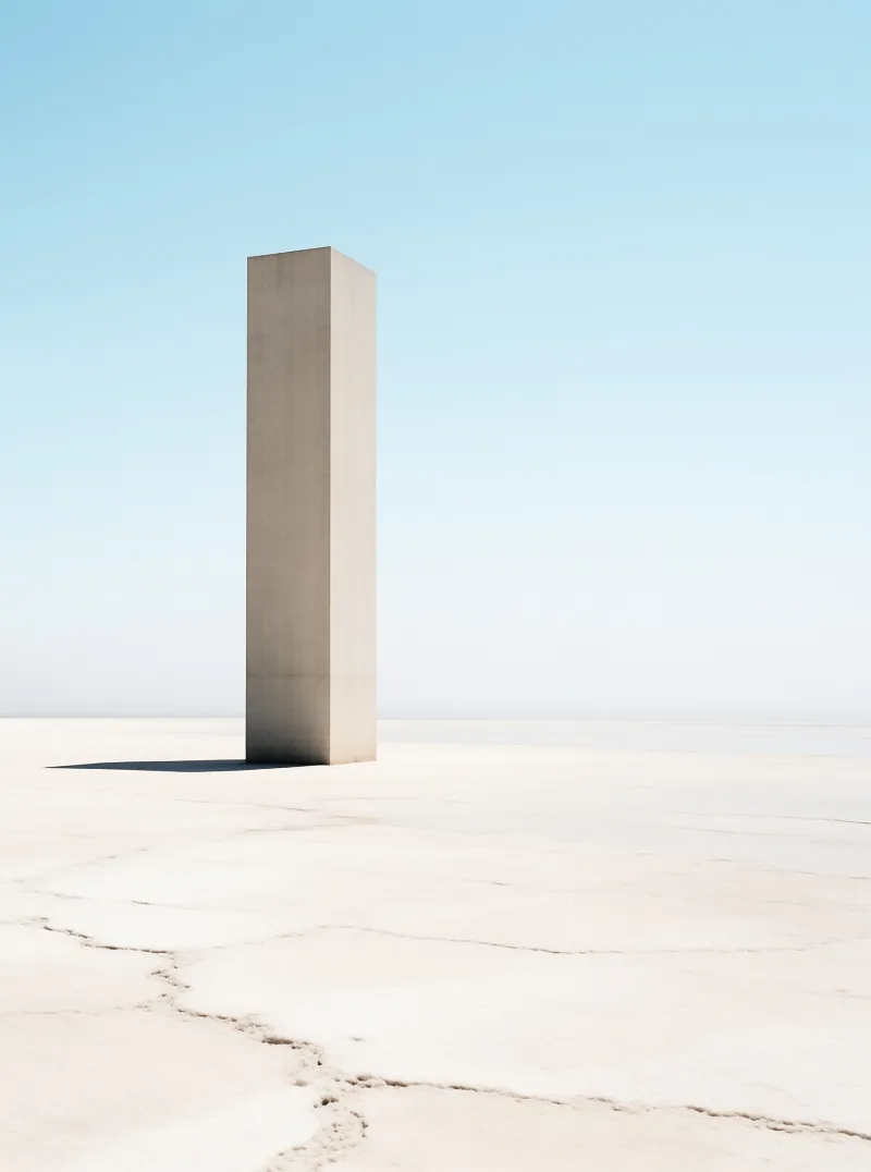 A solitary beige column stands on the cracked earth of a vast salt flat beneath a clear sky