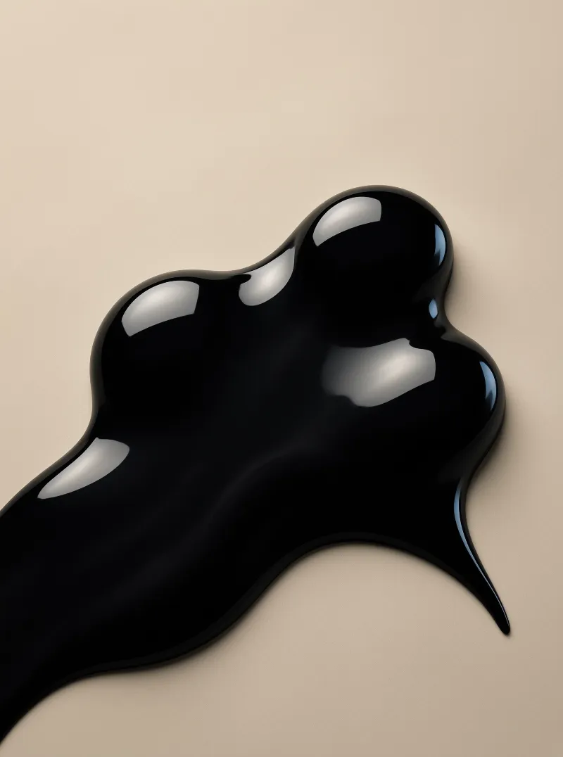 A glossy black liquid blob spreads irregularly across a smooth beige surface with bright white reflections