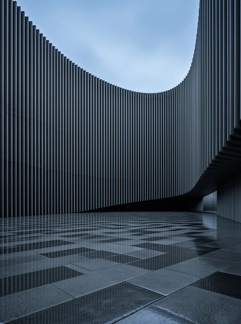 A sweeping ribbed wall of vertical fins arcs above a rain-slicked stone plaza reflecting the pale blue sky.
