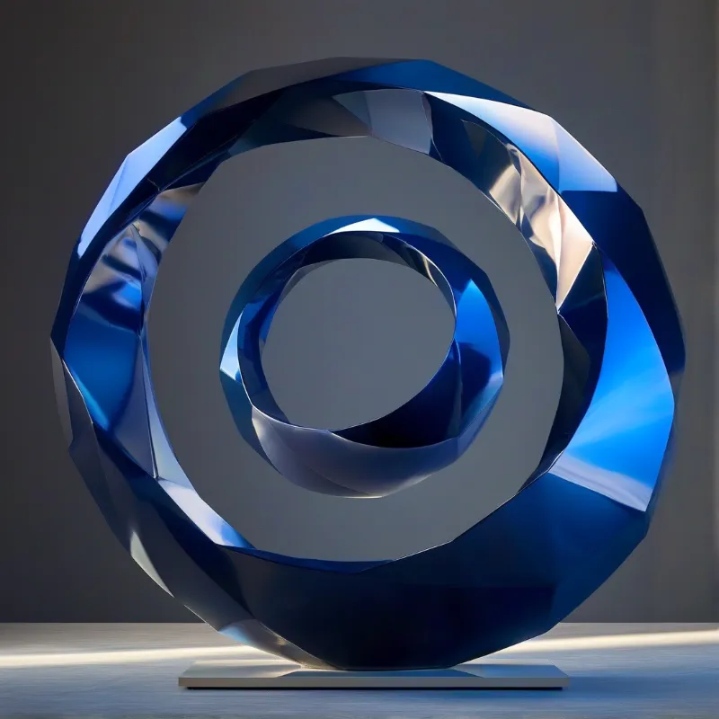 A shiny faceted blue ring sculpture with a cutout spiral design sits on a white base against a dark grey wall.