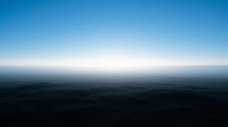 A dark expanse of water stretches beneath a bright gradient sky near the horizon.