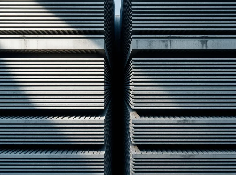 Symmetrical metal facade detail showing horizontal panels converging toward a dark vertical joint