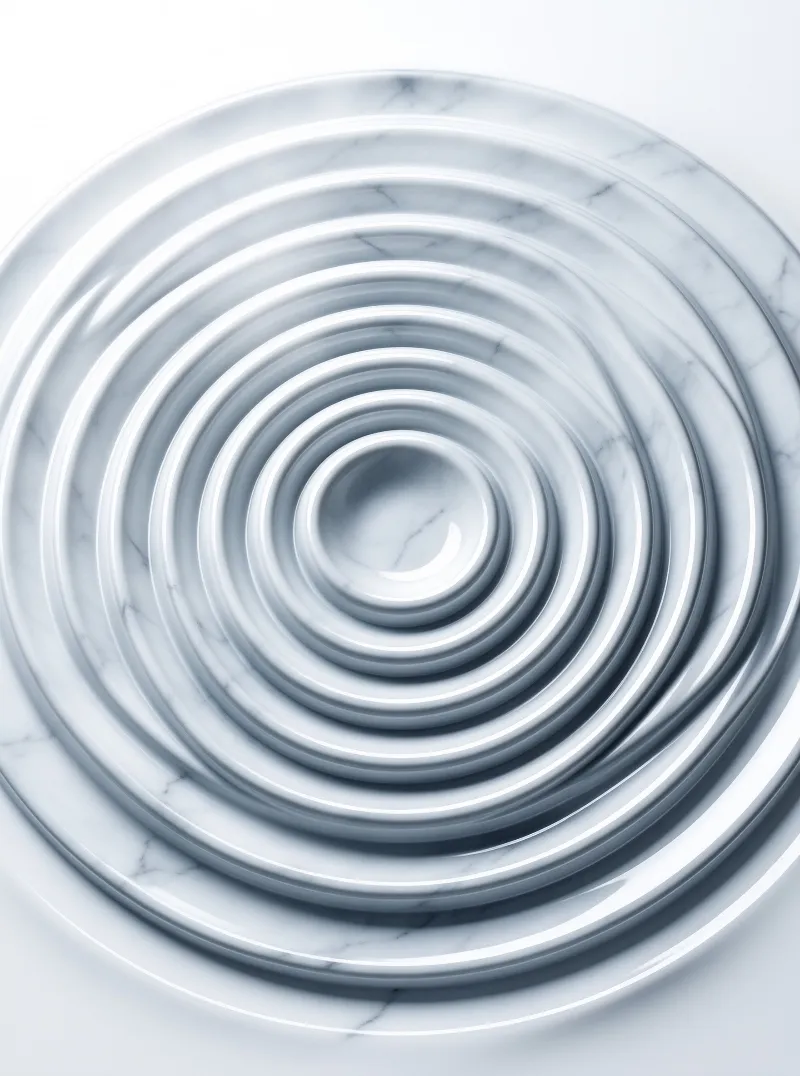 A top down view of concentric polished white marble rings with soft shadows in the valleys between curved ridges