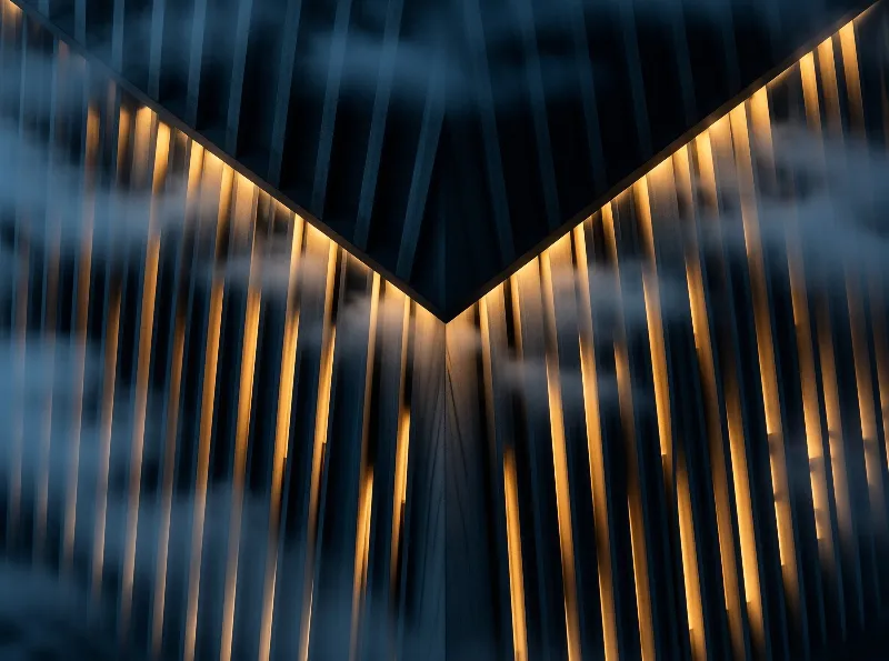 An angled corner of slatted dark wood ceiling panels is lit by warm golden light that cuts through drifting blue haze