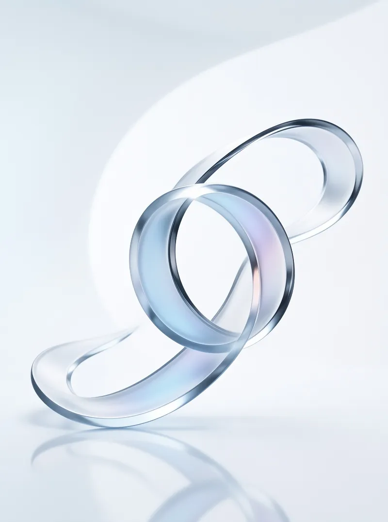 A clear twisted glass ribbon forms a knot shape resting on a reflective white surface under bright light.