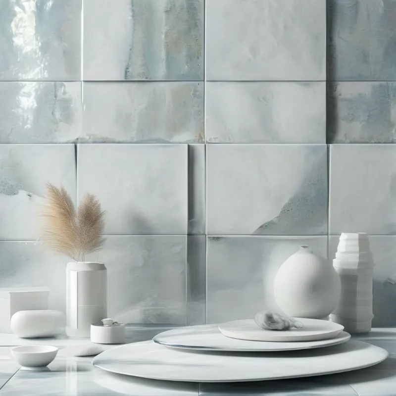 Minimalist arrangement of white pottery and dried grass set against a wall of glossy blue marble tiles.