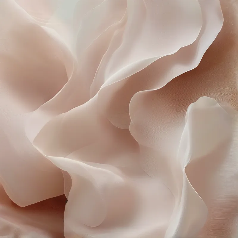 Close-up of translucent cream and peach fabric folding into gentle curves with soft even lighting across the surface.