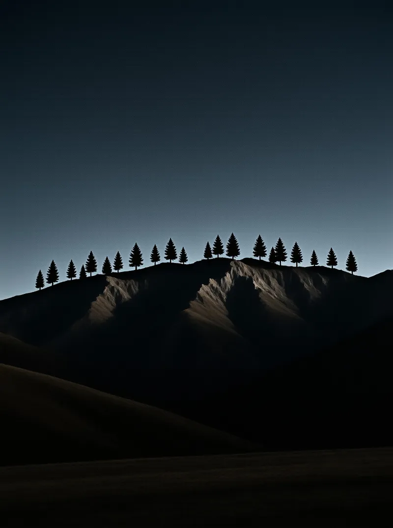 Dark pine trees form a silhouette along a mountain ridge under a deepening blue sky at dusk.