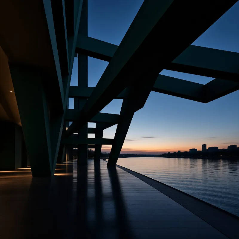 Dark architectural beams overlook calm water at twilight with a gradient orange horizon line in the distance.