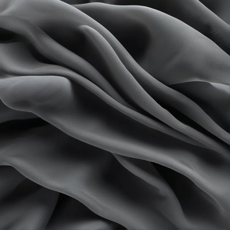 Detailed view of dark grey textile material revealing smooth curves and shadow depth.