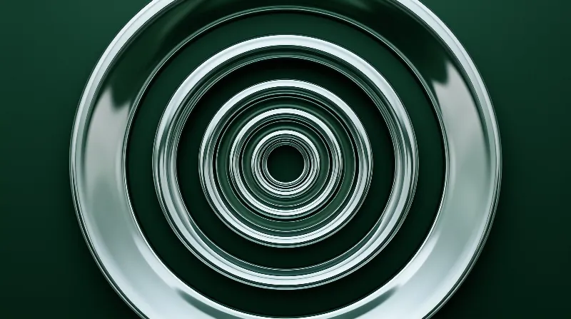 A metallic disc displays concentric green ripples with smooth light reflections across its curved surface.