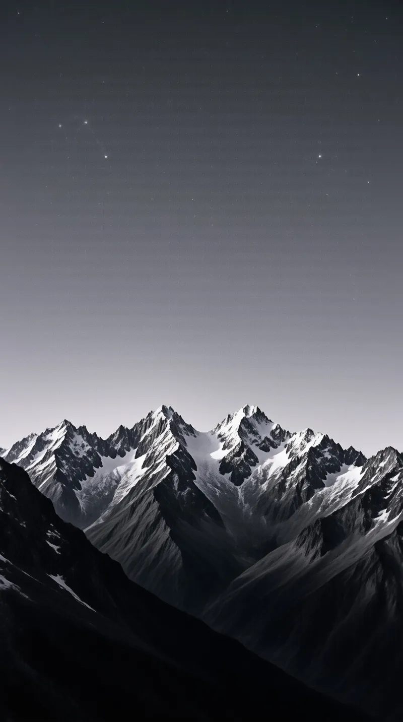 A monochrome landscape shows rugged snowy mountains standing tall beneath a clear sky dotted with distant stars.