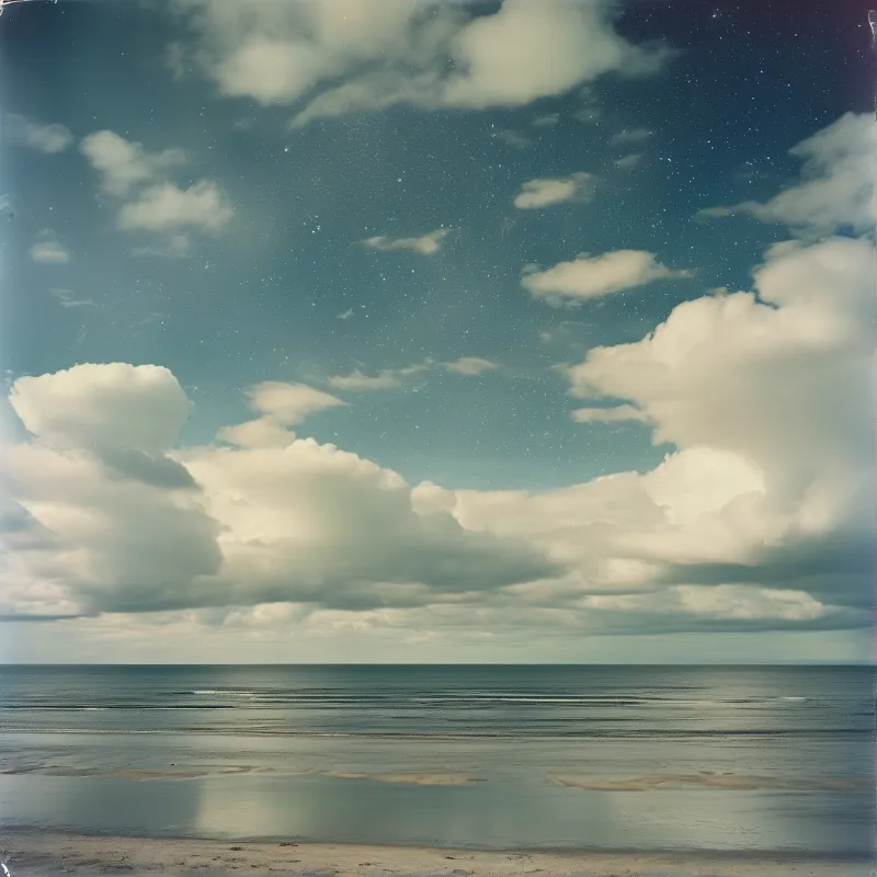 A tranquil seascape featuring a calm ocean beneath a sky filled with large clouds and visible stars.