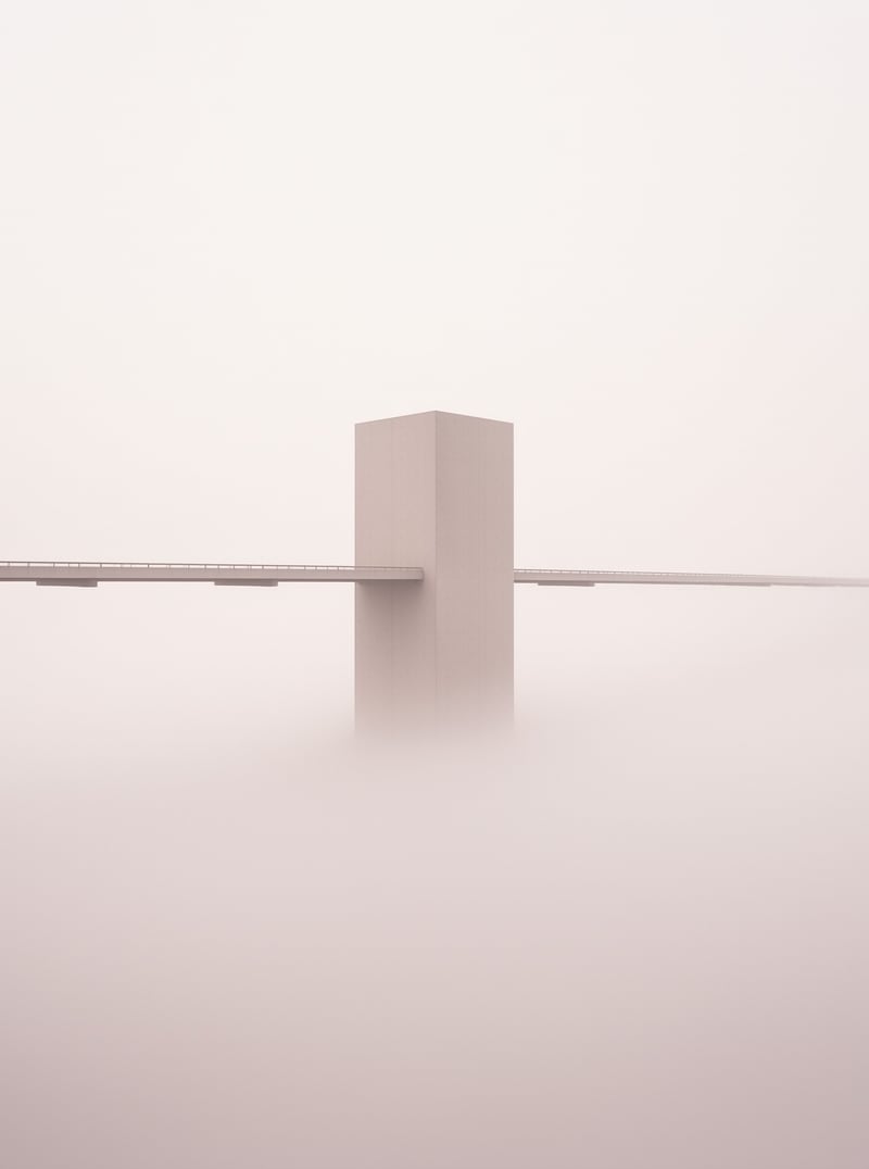 A large rectangular concrete pier supports a bridge deck while disappearing into thick white fog below.