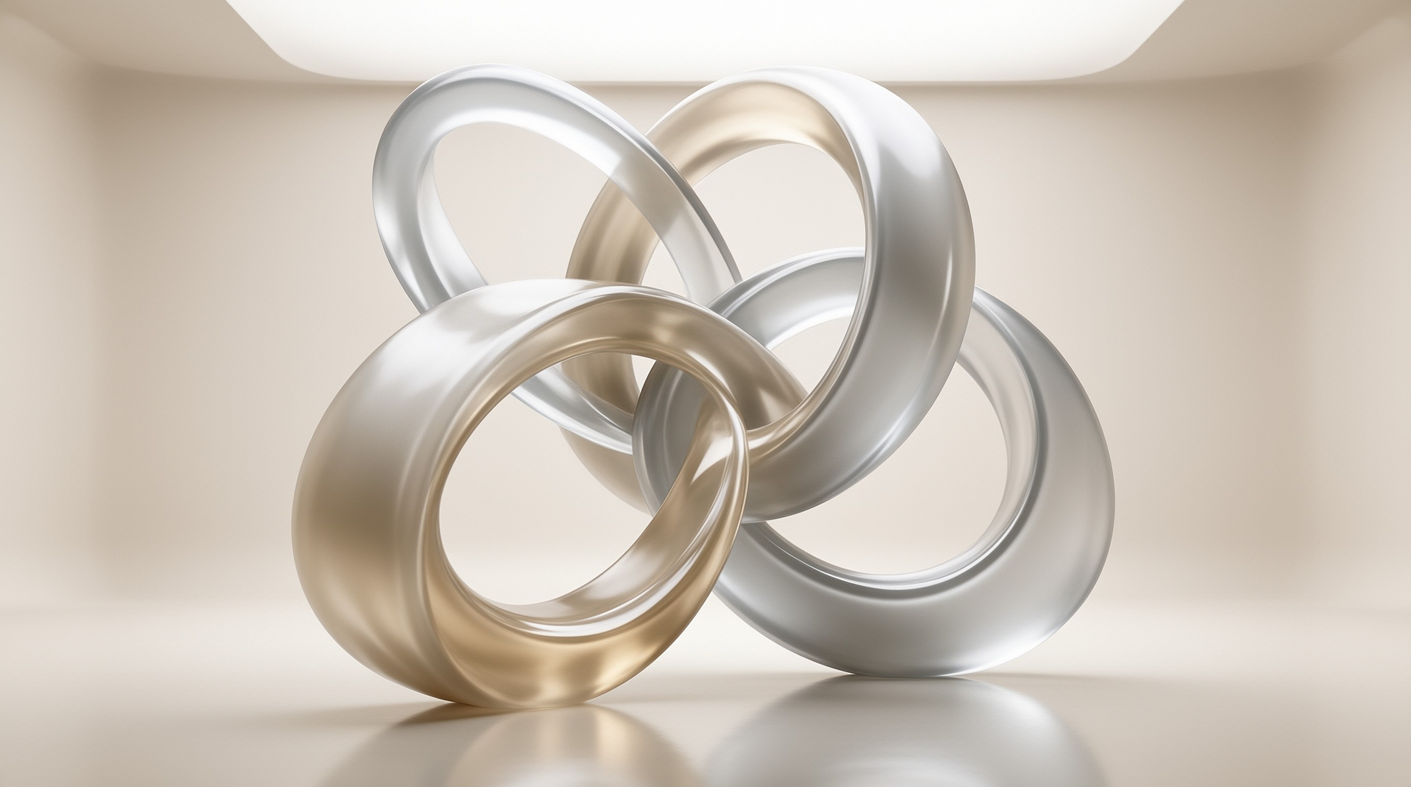 Four thick metal rings in gold and silver tones are intertwined on a plain beige surface with soft lighting.
