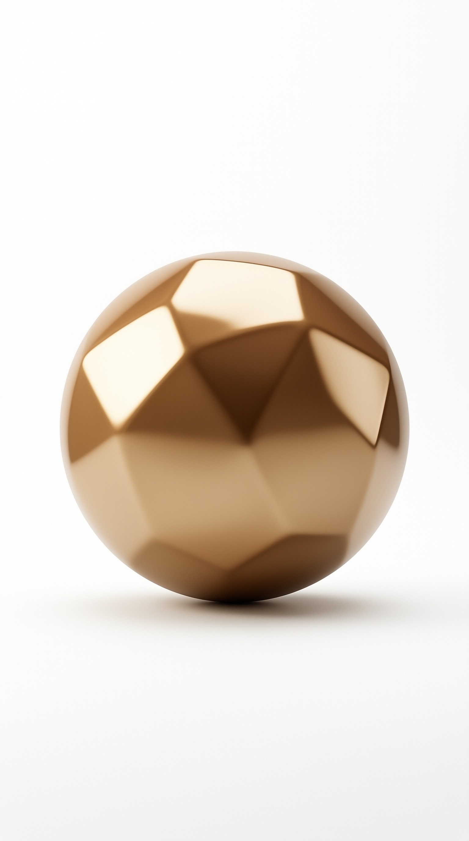 A polished metallic ball with angular geometric cuts sits centered against a seamless light backdrop.