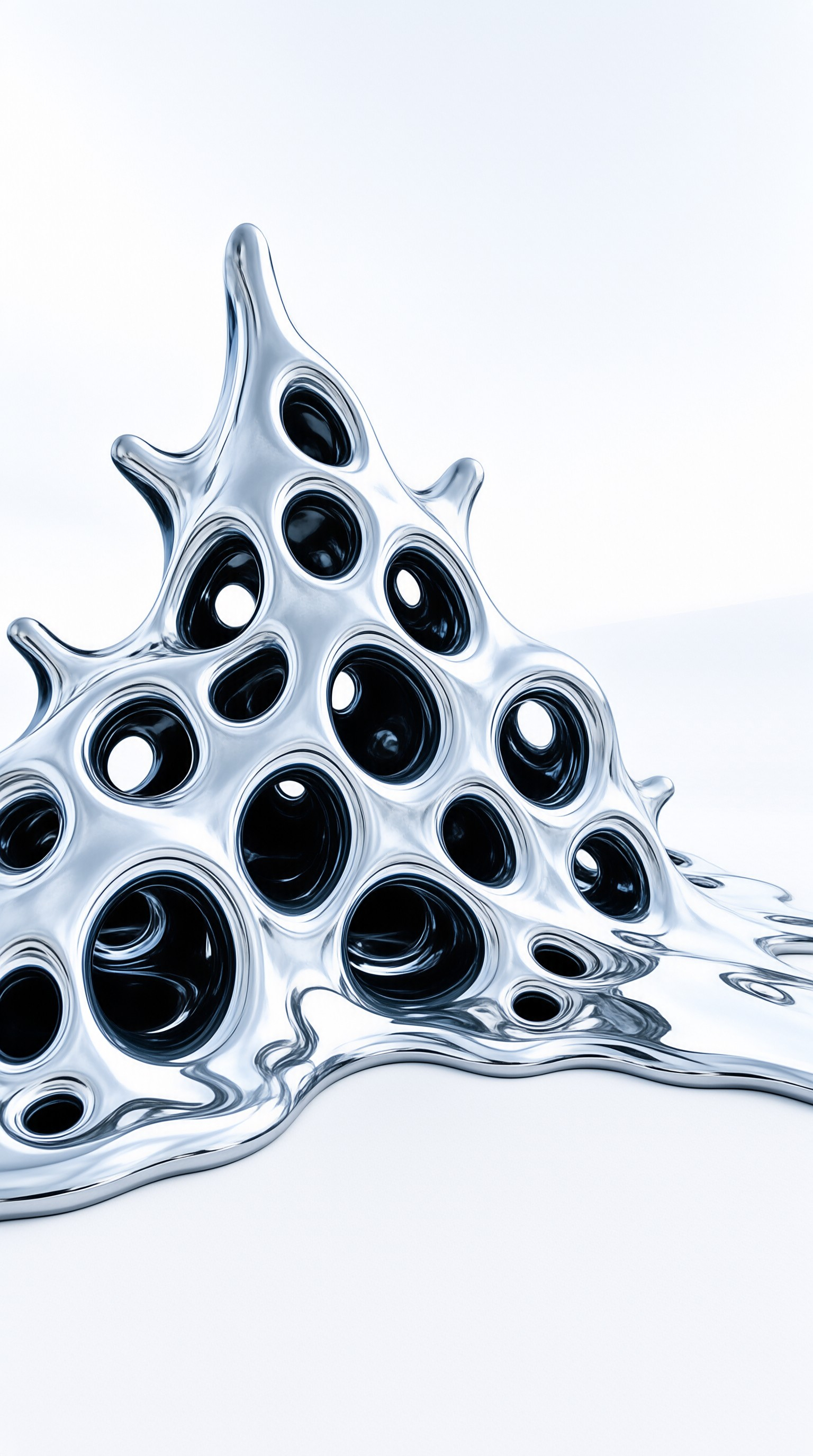 A glossy metallic object with circular holes sits on a white surface under bright studio lighting.