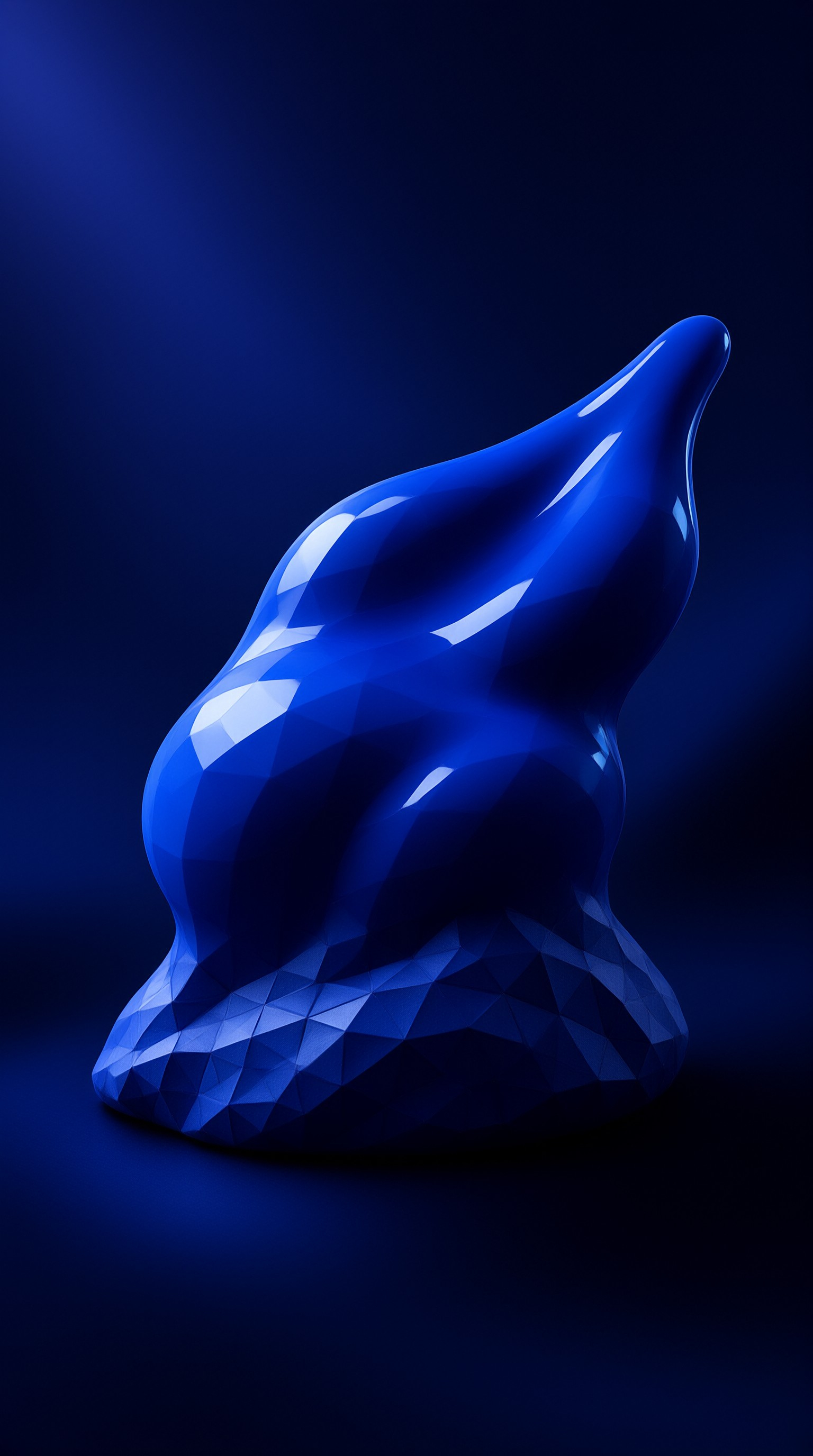 A faceted glossy blue abstract sculpture sits against a deep navy backdrop with bright highlights on its geometric edges.