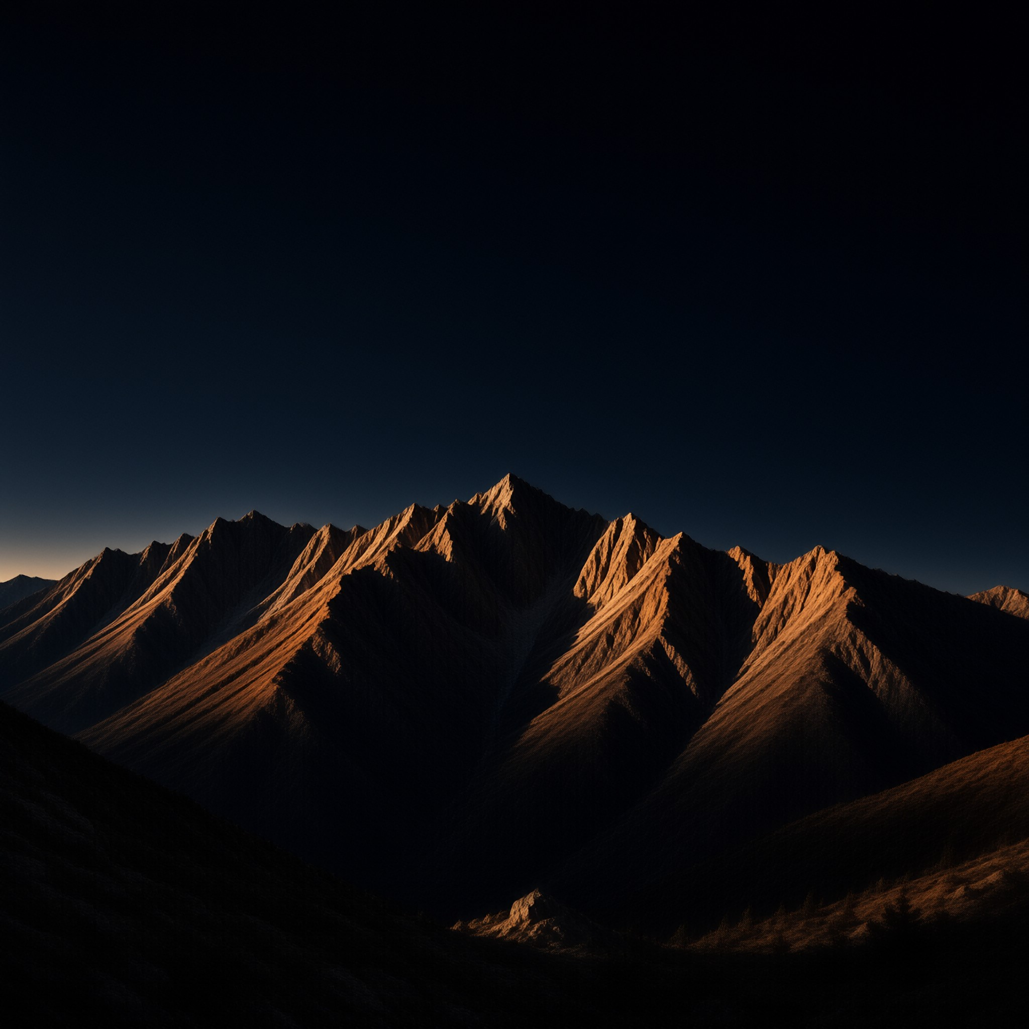 A jagged mountain crest glows amber in low sun, its shadowed slopes falling away beneath a vast dark blue sky.